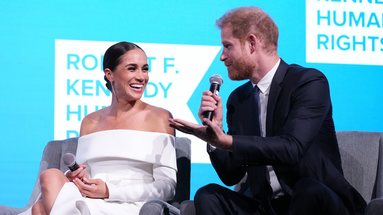 Meghan Markle and Prince Harry holding microphones