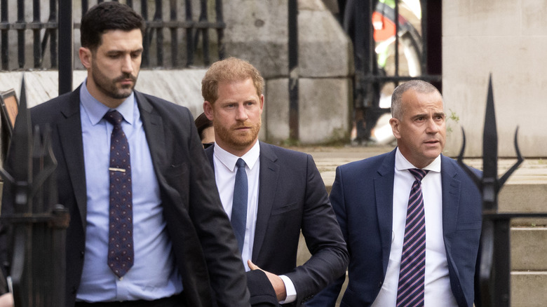 Prince Harry looking serious arriving at court