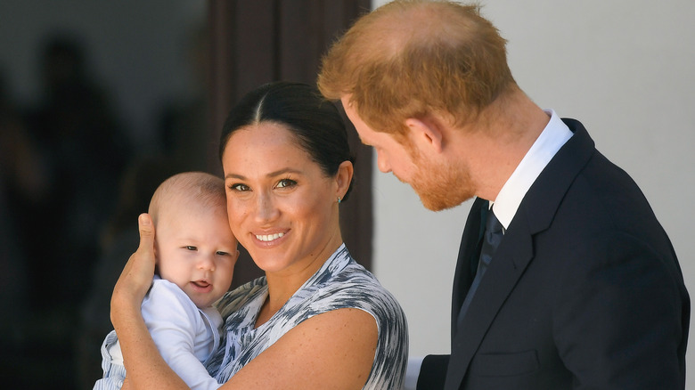 Meghan Markle cuddles a young Archie alongside Harry