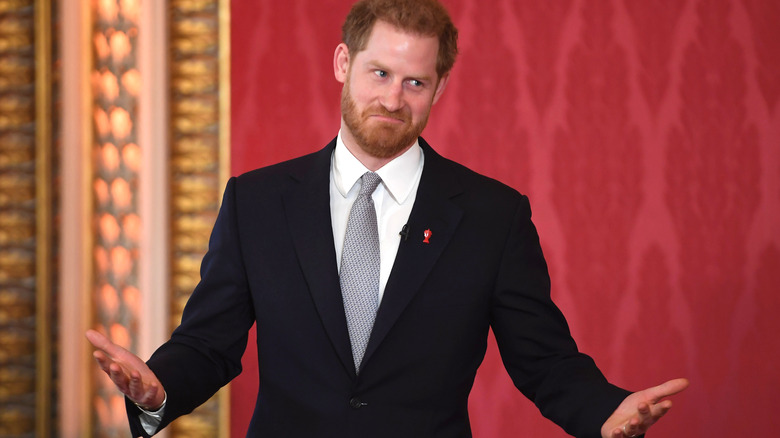 Prince Harry holds his hands up