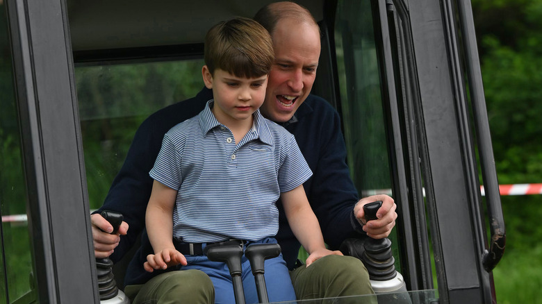 Prince Louis sitting on Prince William's lap in digger