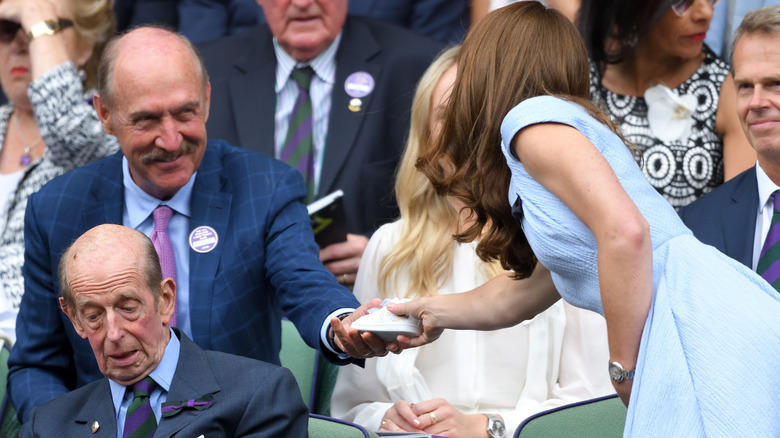 Stan Smith handing Princess Catherine baby shoes at Wimbledon