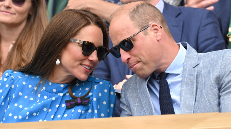 Princess Catherine leaning in to speak to Prince William at Wimbledon