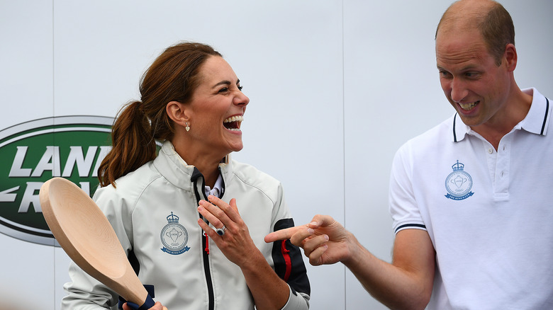 Princess Catherine laughing holding wooden spoon with Prince William  