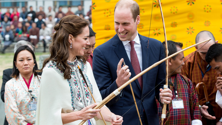 Princess Catherine and Prince William holding a bow and arrow