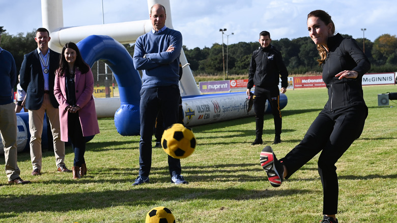 Prince William watching Kate Middleton kick football