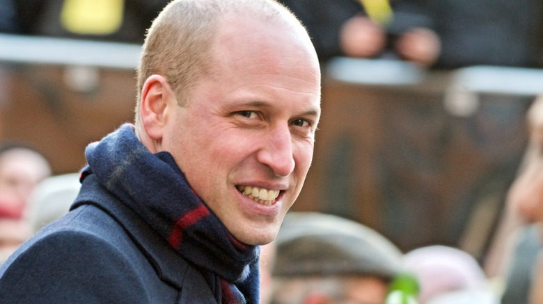 Prince William smiling and wearing scarf