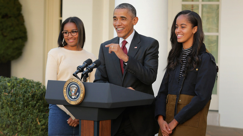 Barack Obama giving a speech with his daughters