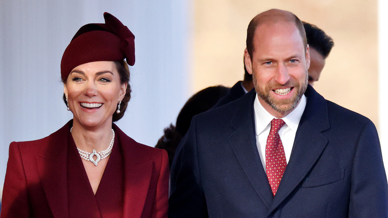 Catherine and William, Princess and Prince of Wales smile, standing next to each other