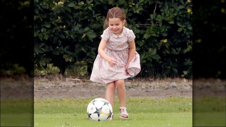 Princess Charlotte playing soccer in a dress