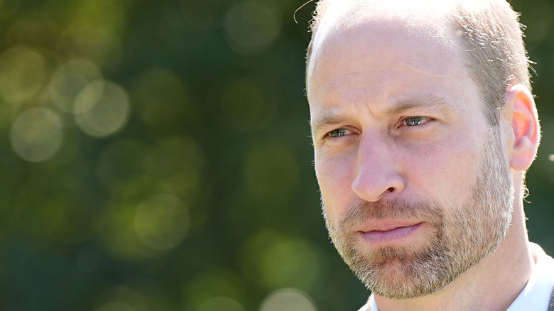 Prince William with a beard looking somber