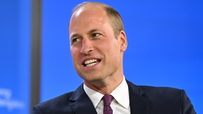 Prince William smiling onstage 