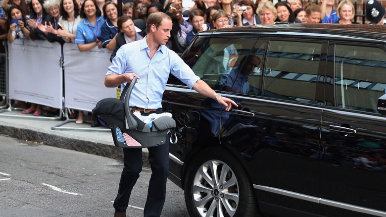 Prince William carrying newborn George to car