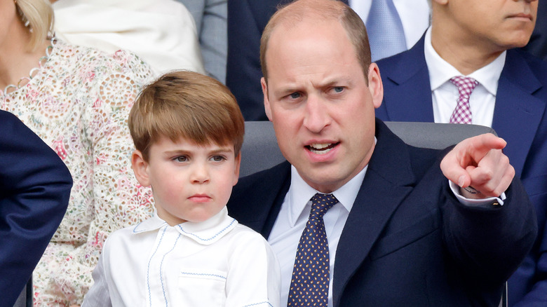 Prince William pointing with Prince Louis