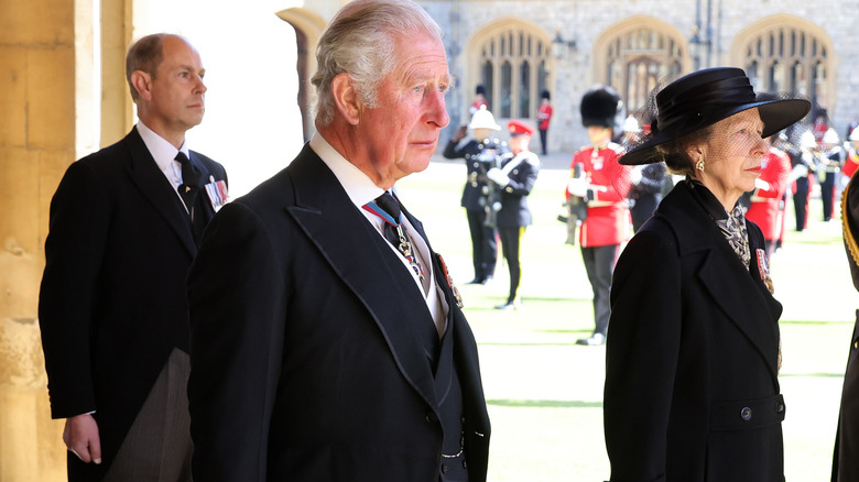 Prince Edward, King Charles, and Princess Anne standing together