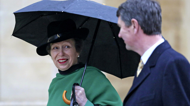 Princess Anne and Sir Timothy Laurence looking at each other in the rain