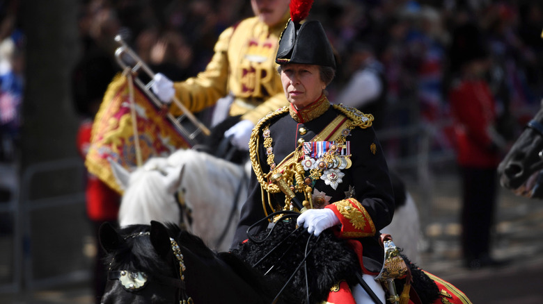 Princess Anne riding a horse in a formal procession