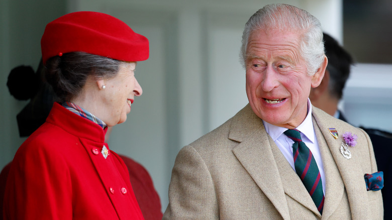 Princess Anne and King Charles smiling at one another