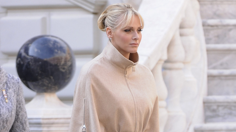 Princess Charlene in beige coat and updo hairstyle