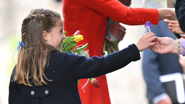 Princess Charlotte accepting purple flower from woman