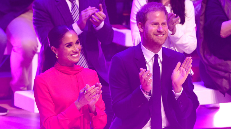 Megahn Markle and Prince Harry clapping at an event