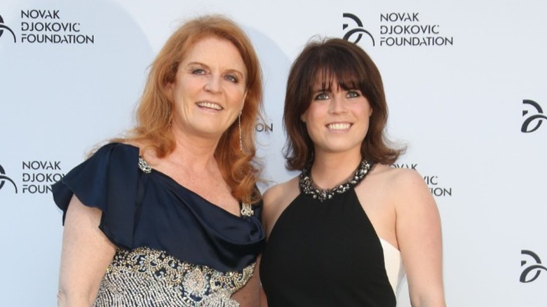 Princess Eugenie with Sarah Ferguson smiling on step-and-repeat