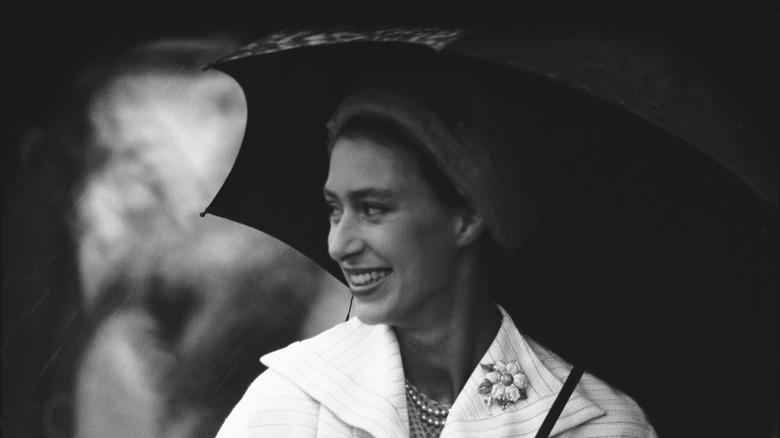 Smiling Princess Margaret holding umbrella