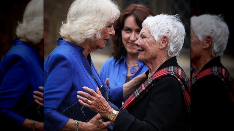 Queen Camilla and Judi Dench hugging 