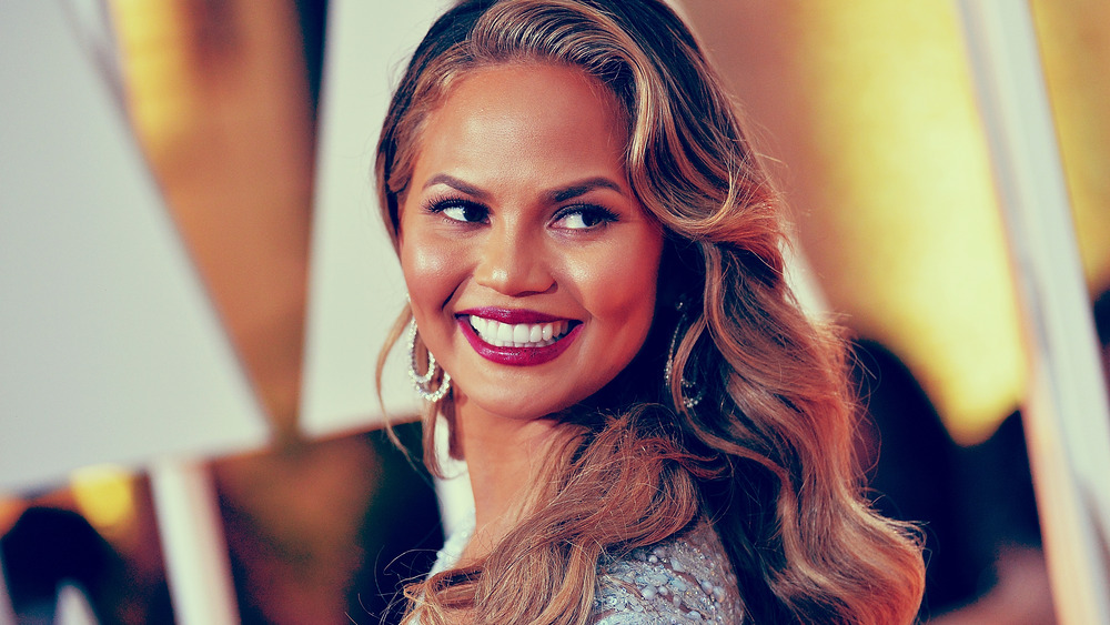 Chrissy Teigen smiles for photographers