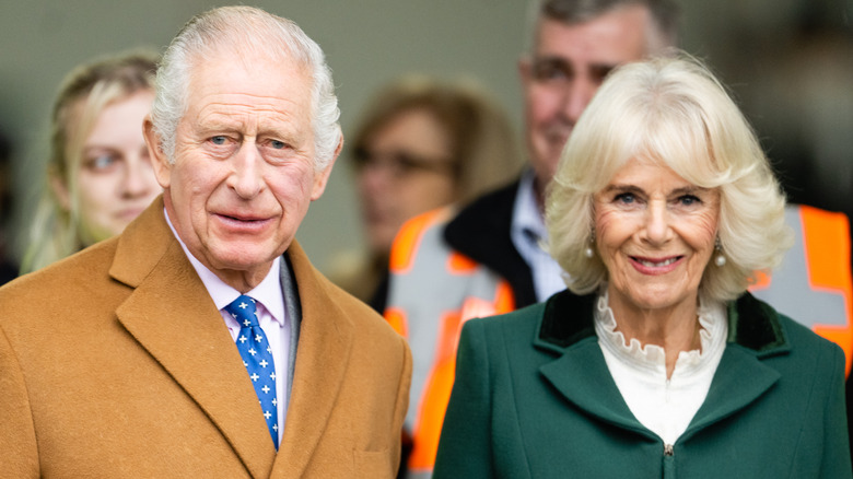 King Charles III and Queen Camilla standing together outside, wearing outdoor coats