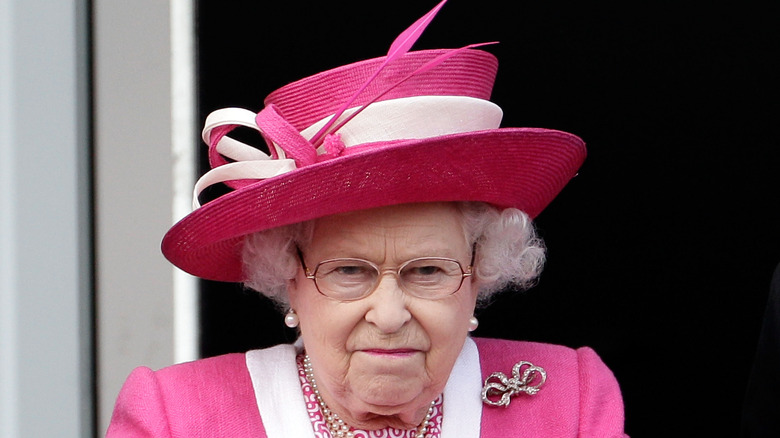 Queen Elizabeth fuming in a pink hat