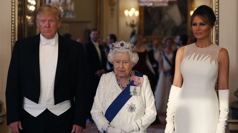 Melania Trump, Queen Elizabeth, and Donald Trump standing together