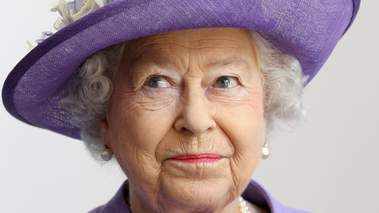 Queen Elizabeth looks coy in a purple hat
