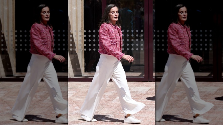 Queen Letizia walking in red jacket and white pants