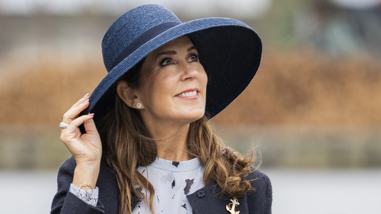 Queen Mary smiling in blue hat