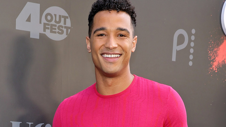 Devin Way smiling in pink on a black carpet