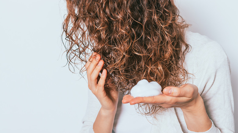 woman applying mousse to damp hair