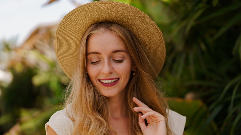 Woman with wavy hair wearing hat