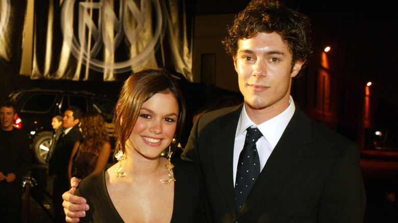 Adam Brody arm around Rachel Bilson posing at an event