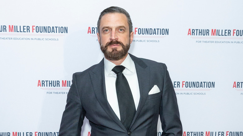 Raúl Esparza wearing a gray suit