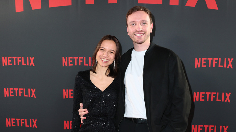 Ilias Pappas and Alina from "Love Is Blind: Germany" pose in front of a Netflix sign