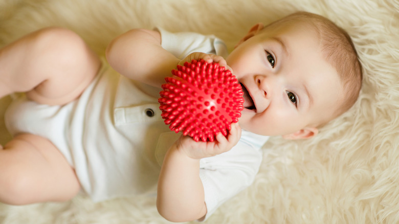 baby holding red ball