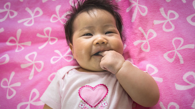 baby wearing pink onesie with heart