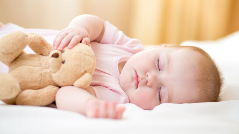 little baby girl sleeping with teddy bear