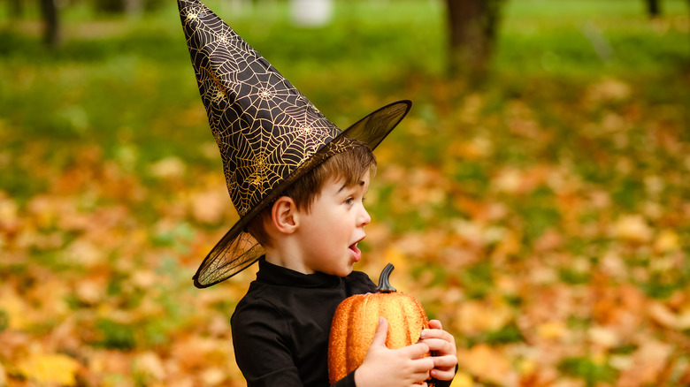 Baby boy holding pumpkin