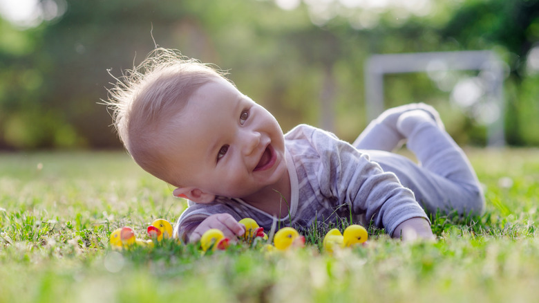 Baby rolling in meadow