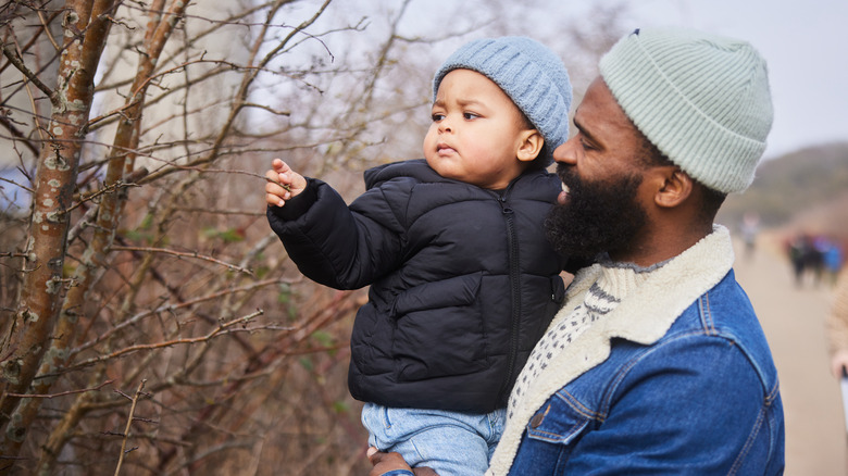 Baby boy touching tree