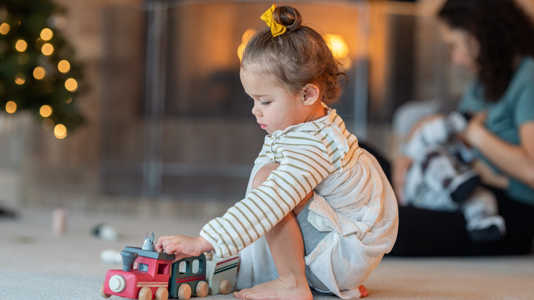 Baby playing in front of fireplace