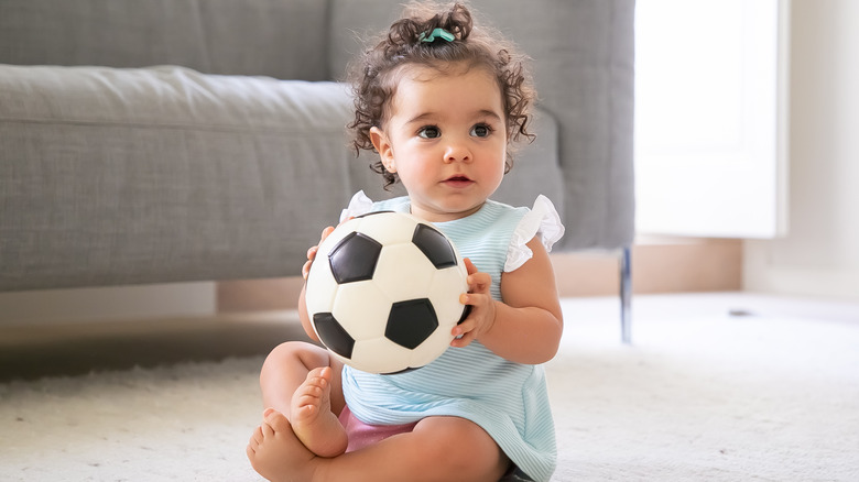 Baby girl holding soccer ball