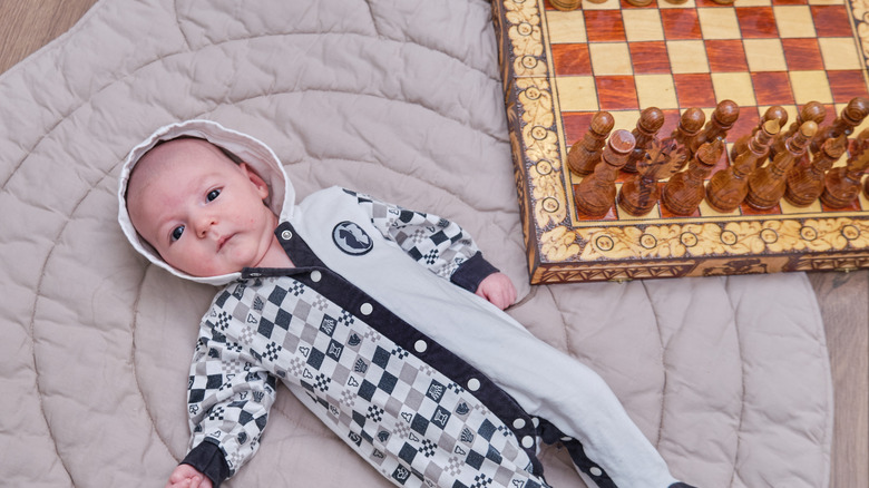 Baby next to chess set